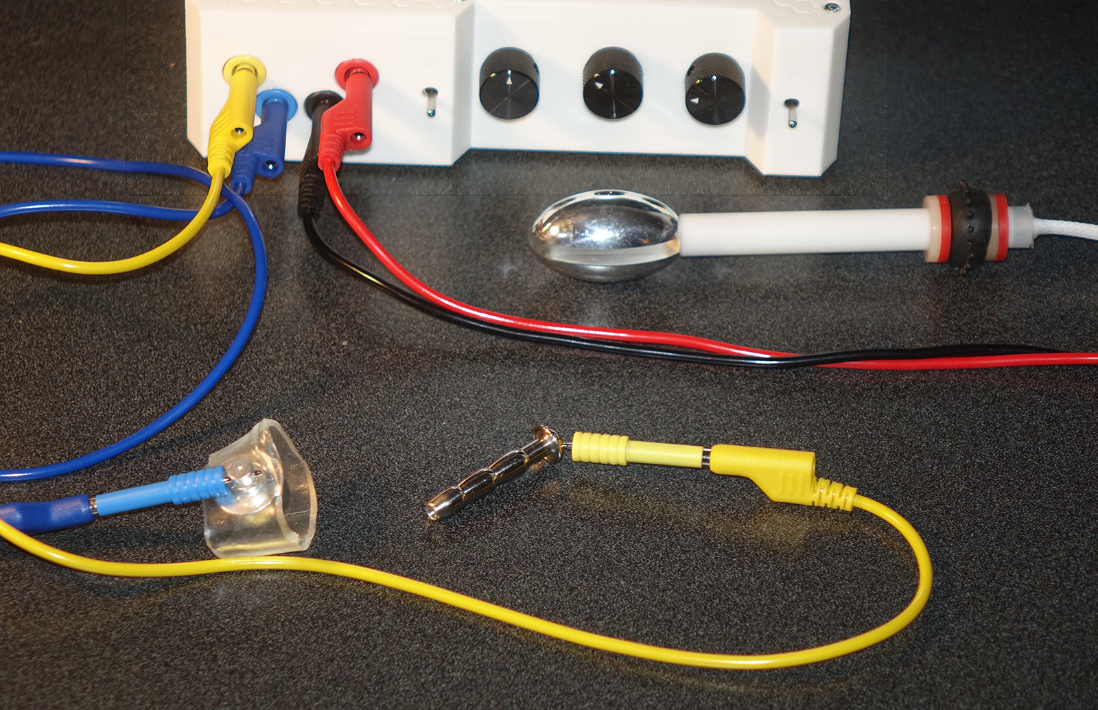 A close view of the Estim Hero and the electrode setup.